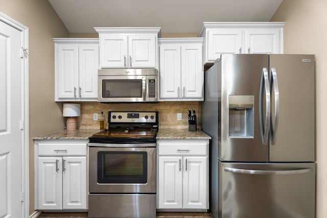 105 Mission Crest Cir, Lindale, TX 75771 - kitchen with appliances with stainless steel finishes, white cabinetry, decorative backsplash, and light stone counters