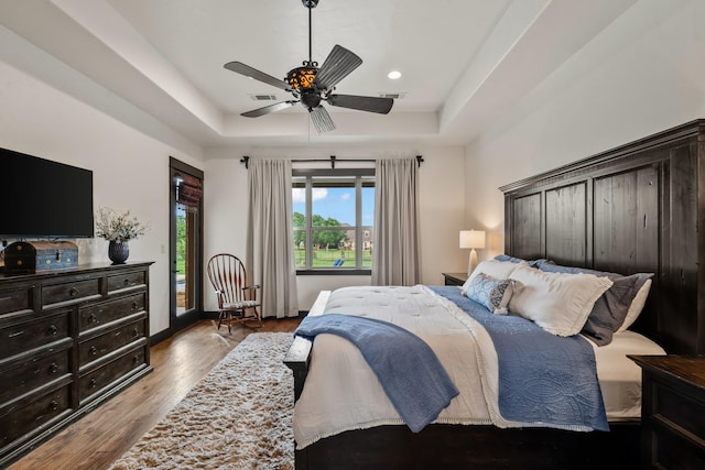 215 Thornhill Cir, Double Oak, TX 75077 - bedroom with a tray ceiling, access to outside, wood finished floors, a ceiling fan, and baseboards