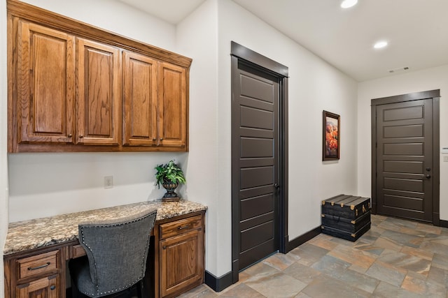 215 Thornhill Cir, Double Oak, TX 75077 - interior space featuring built in desk, baseboards, stone finish floors, and recessed lighting