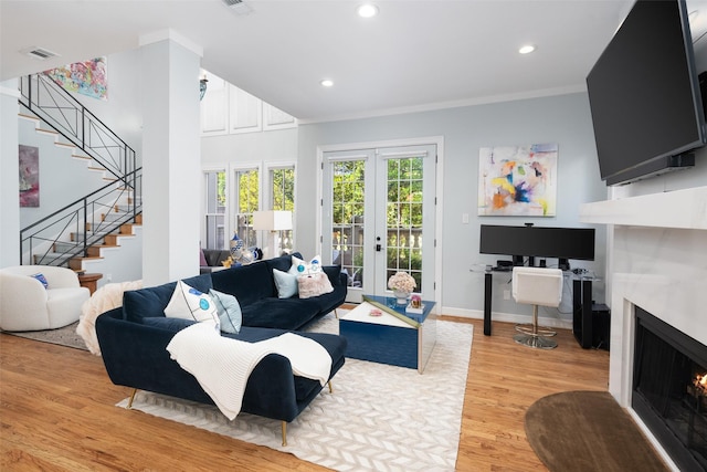 3702 Holland Ave Unit 1, Dallas, TX 75219 - living room with a lit fireplace, stairs, light wood finished floors, french doors, and recessed lighting