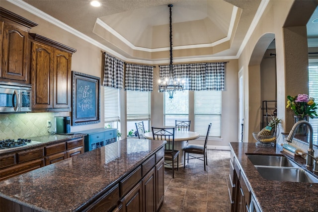 3420 Grayson Ct, Hurst, TX 76054 - kitchen featuring a sink, stainless steel microwave, tasteful backsplash, a chandelier, and crown molding