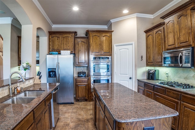 3420 Grayson Ct, Hurst, TX 76054 - kitchen with appliances with stainless steel finishes, a sink, arched walkways, dark stone countertops, and backsplash