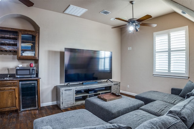 3420 Grayson Ct, Hurst, TX 76054 - living room featuring beverage cooler, a ceiling fan, dark wood-style floors, bar with sink, and baseboards