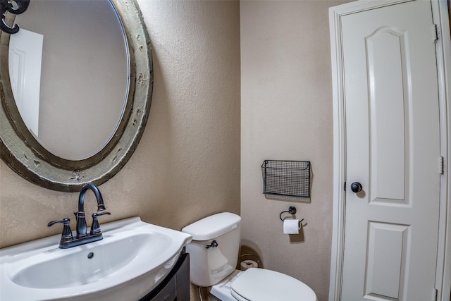 3420 Grayson Ct, Hurst, TX 76054 - bathroom with toilet, a textured wall, and vanity