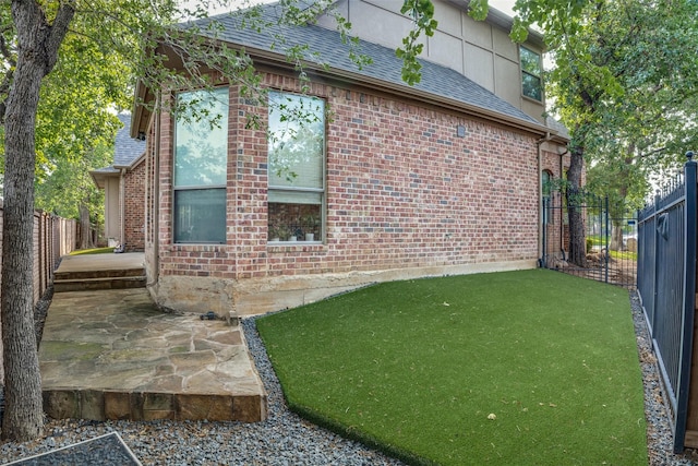 3420 Grayson Ct, Hurst, TX 76054 - view of property exterior with a fenced backyard, roof with shingles, brick siding, and a patio