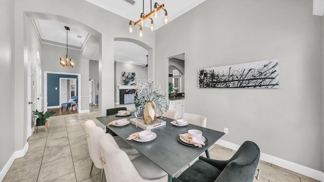 5709 Courtney Cir, Haltom City, TX 76137 - dining room featuring arched walkways, ornamental molding, a towering ceiling, a chandelier, and baseboards