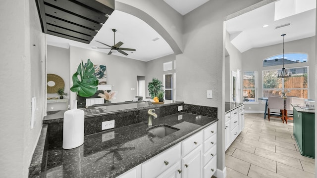 5709 Courtney Cir, Haltom City, TX 76137 - kitchen with a sink, white cabinetry, ceiling fan, dark stone counters, and pendant lighting
