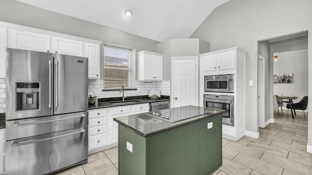 5709 Courtney Cir, Haltom City, TX 76137 - kitchen with appliances with stainless steel finishes, a sink, backsplash, vaulted ceiling, and a kitchen island