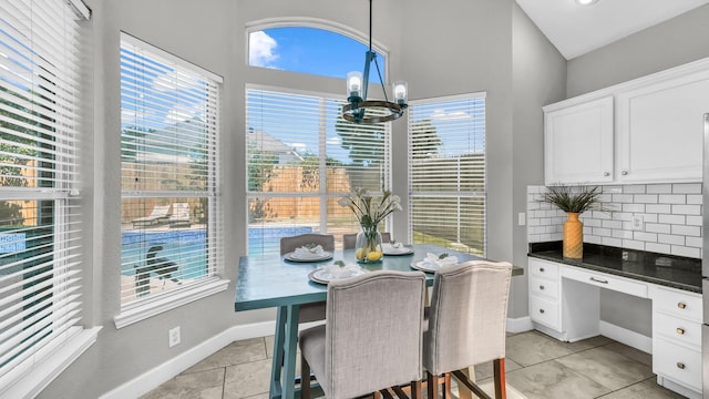 5709 Courtney Cir, Haltom City, TX 76137 - dining space with plenty of natural light, a chandelier, light tile patterned flooring, and baseboards