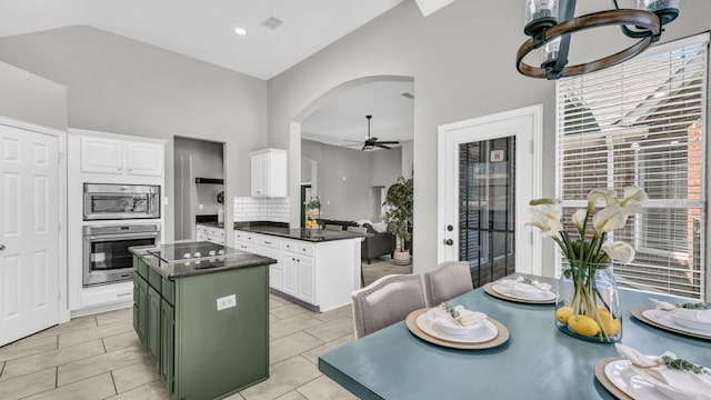 5709 Courtney Cir, Haltom City, TX 76137 - kitchen with appliances with stainless steel finishes, high vaulted ceiling, ceiling fan, arched walkways, and dark countertops