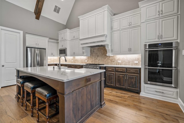 6286 Brentway Rd, Frisco, TX 75034 - kitchen with stainless steel appliances, a sink, custom range hood, light wood-type flooring, and white cabinetry