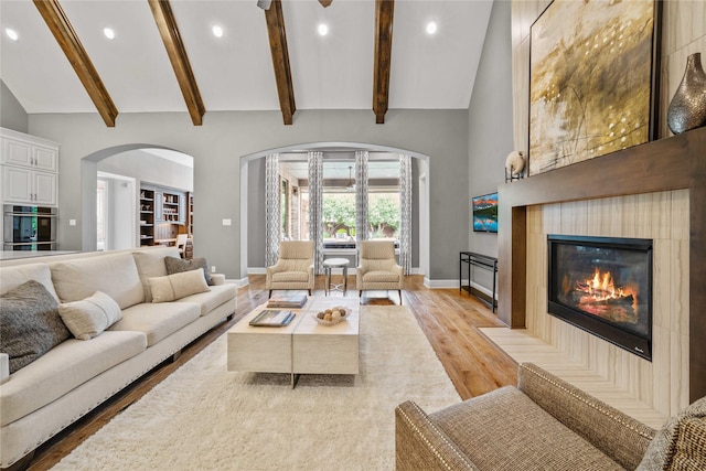 6286 Brentway Rd, Frisco, TX 75034 - living room with arched walkways, light wood-style flooring, a fireplace, recessed lighting, and baseboards