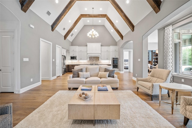 6286 Brentway Rd, Frisco, TX 75034 - living area featuring high vaulted ceiling, arched walkways, a chandelier, beam ceiling, and light wood-type flooring