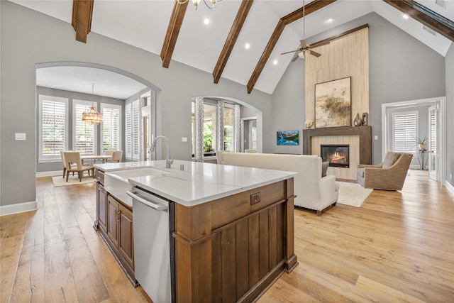 6286 Brentway Rd, Frisco, TX 75034 - kitchen with stainless steel dishwasher, a sink, arched walkways, a fireplace, and high vaulted ceiling