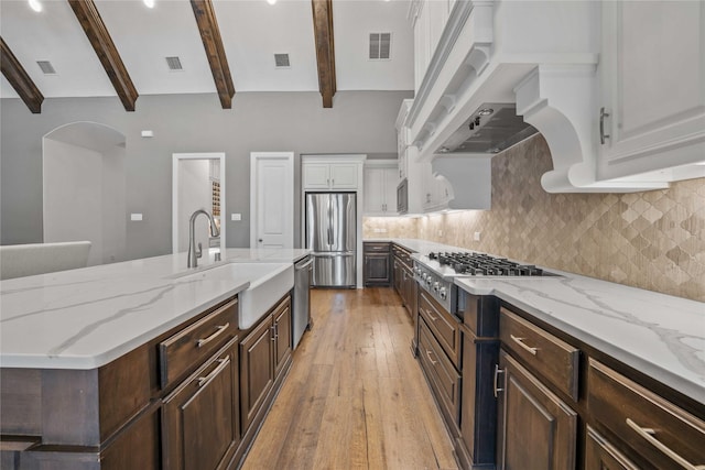 6286 Brentway Rd, Frisco, TX 75034 - kitchen with appliances with stainless steel finishes, a sink, beam ceiling, white cabinetry, and light wood-style flooring