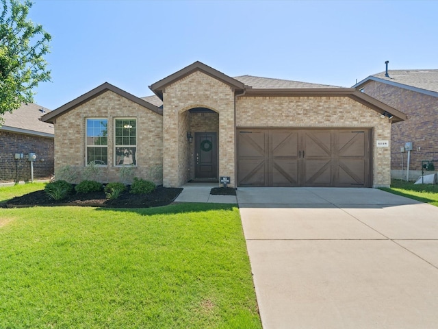 4148 Agatha Ln, Celina, TX 76227 - french country inspired facade featuring brick siding, a garage, concrete driveway, and a front yard