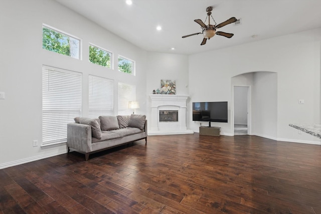 736 Kilbridge Ln, Coppell, TX 75019 - living room featuring a glass covered fireplace, dark wood-style flooring, ceiling fan, recessed lighting, and arched walkways
