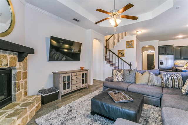 4012 Gennaker Dr, Denton, TX 76210 - living room with arched walkways, stairway, a ceiling fan, a fireplace, and wood finished floors