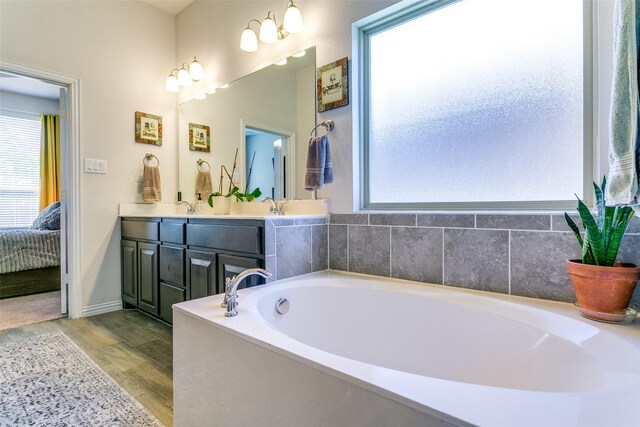 4012 Gennaker Dr, Denton, TX 76210 - bathroom with ensuite bathroom, a bath, double vanity, and wood finished floors