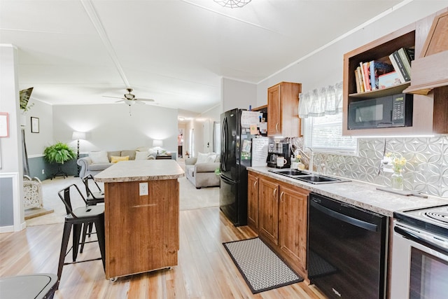 239 County Road 3586, Paradise, TX 76073 - kitchen featuring black appliances, a sink, a center island, open floor plan, and light wood finished floors