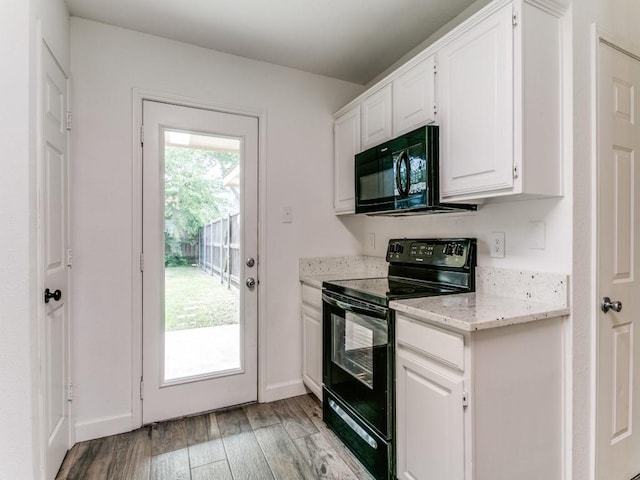 117 Summer Place Dr, Coppell, TX 75019 - kitchen with black appliances, light wood-style floors, white cabinetry, light stone counters, and baseboards