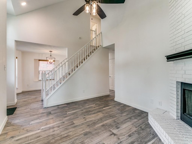 117 Summer Place Dr, Coppell, TX 75019 - unfurnished living room with stairway, a high ceiling, wood finished floors, a brick fireplace, and baseboards