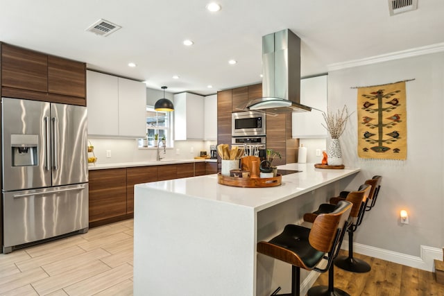 605 Cliffside Dr, Richardson, TX 75080 - kitchen featuring stainless steel appliances, island range hood, modern cabinets, a breakfast bar area, and a peninsula