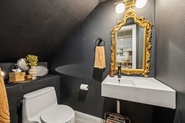 605 Cliffside Dr, Richardson, TX 75080 - half bathroom with toilet, vaulted ceiling, a textured wall, and baseboards