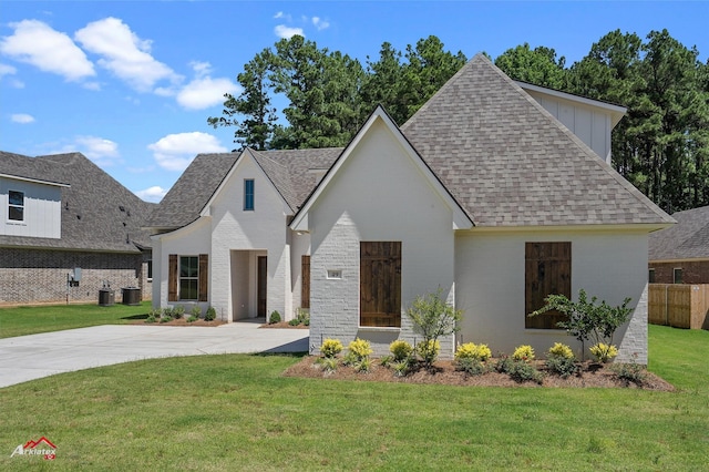 49 Turtle Creek Dr, Benton, LA 71006 - view of front of home with a shingled roof, a front yard, cooling unit, and brick siding
