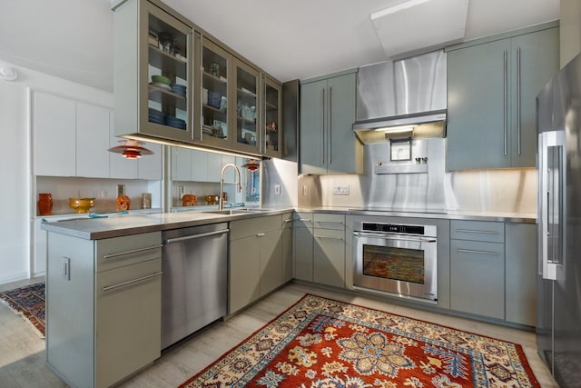3310 Fairmount St Unit 16B, Dallas, TX 75201 - kitchen featuring appliances with stainless steel finishes, stainless steel counters, a sink, and wall chimney exhaust hood