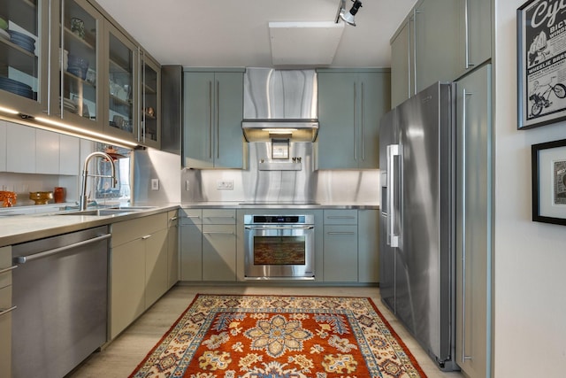 3310 Fairmount St Unit 16B, Dallas, TX 75201 - kitchen with stainless steel counters, stainless steel appliances, a sink, wall chimney exhaust hood, and light wood finished floors