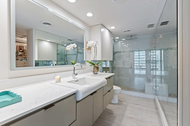 3310 Fairmount St Unit 16B, Dallas, TX 75201 - bathroom featuring a stall shower, vanity, toilet, wood finished floors, and recessed lighting