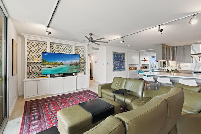 3310 Fairmount St Unit 16B, Dallas, TX 75201 - living room featuring rail lighting, ceiling fan, light wood finished floors, and baseboards