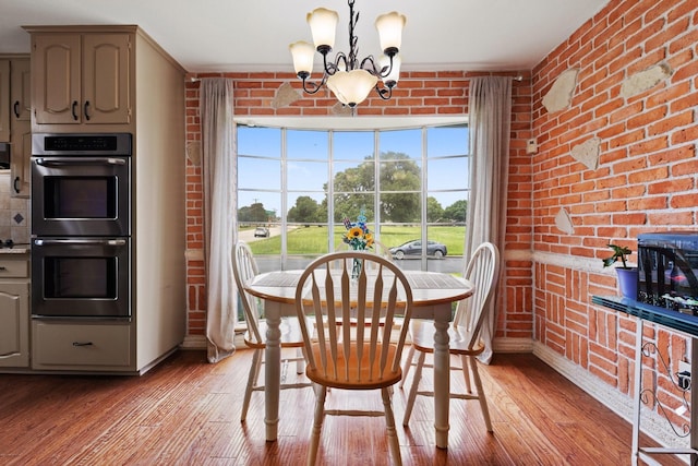 1720 Norwood Dr, Hurst, TX 76054 - dining room with a chandelier, light wood-style flooring, baseboards, and brick wall