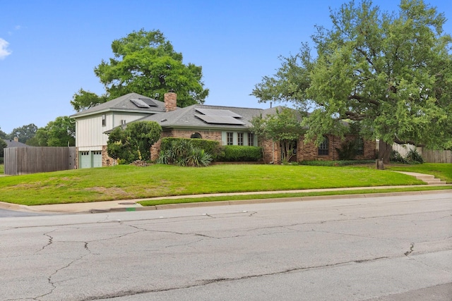 1720 Norwood Dr, Hurst, TX 76054 - view of front of property featuring roof mounted solar panels, an attached garage, a chimney, and brick siding