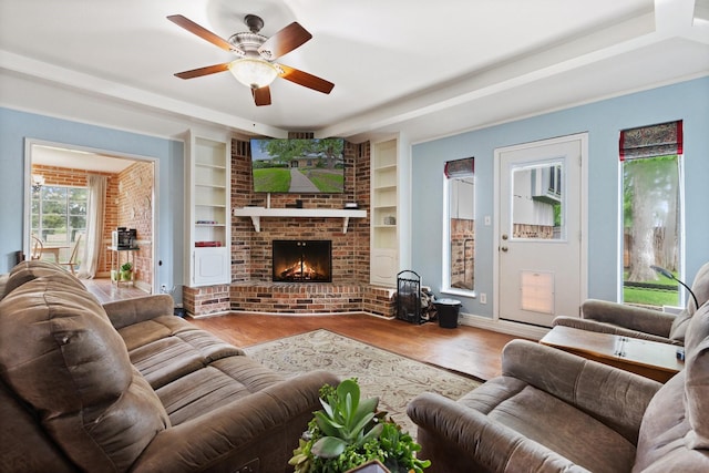 1720 Norwood Dr, Hurst, TX 76054 - living room featuring wood finished floors, a ceiling fan, built in features, baseboards, and a fireplace