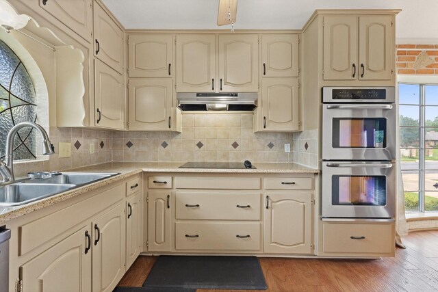 1720 Norwood Dr, Hurst, TX 76054 - kitchen with cream cabinetry, appliances with stainless steel finishes, a sink, and under cabinet range hood