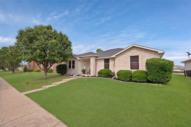 1819 Wildrose Dr, Rockwall, TX 75032 - ranch-style home featuring a front yard, brick siding, and central air condition unit