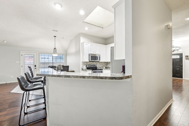 1629 Big Bend Dr, Lewisville, TX 75077 - kitchen with appliances with stainless steel finishes, baseboards, dark wood-type flooring, white cabinetry, and a textured ceiling