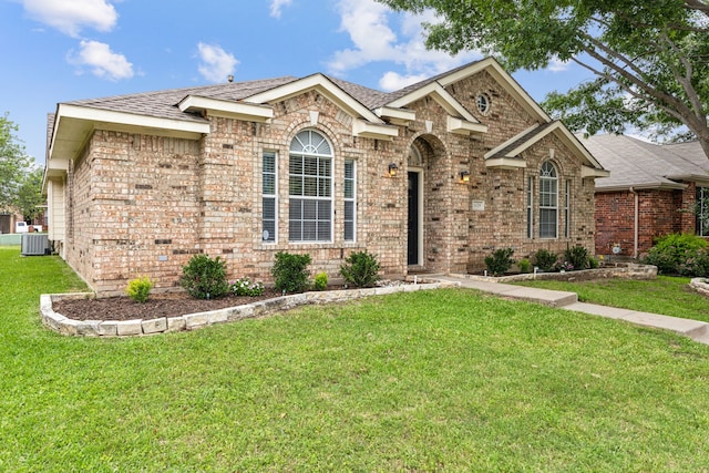 1629 Big Bend Dr, Lewisville, TX 75077 - traditional home featuring brick siding, a front yard, central AC, and roof with shingles