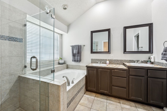1629 Big Bend Dr, Lewisville, TX 75077 - bathroom featuring vaulted ceiling, double vanity, a shower stall, a garden tub, and tile patterned floors