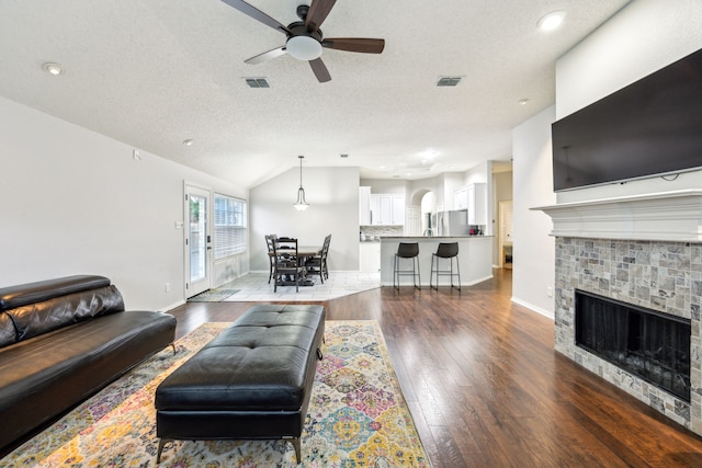 1629 Big Bend Dr, Lewisville, TX 75077 - living area featuring ceiling fan, wood finished floors, a fireplace, baseboards, and a textured ceiling