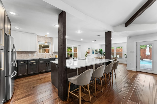 2909 N Britain Rd, Irving, TX 75062 - kitchen with stainless steel refrigerator with ice dispenser, a kitchen breakfast bar, dark wood-style floors, a sink, and beamed ceiling
