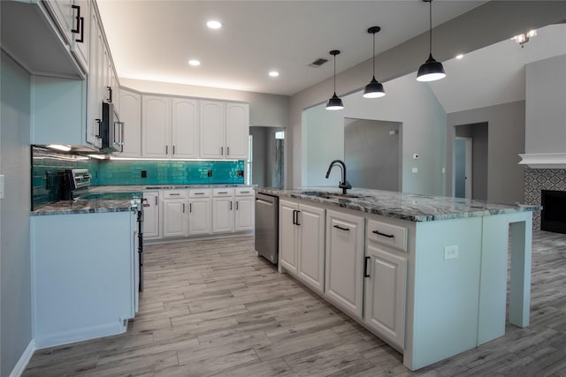 103 Saddle Club Rd, Weatherford, TX 76088 - kitchen with appliances with stainless steel finishes, tasteful backsplash, light wood finished floors, a sink, and lofted ceiling