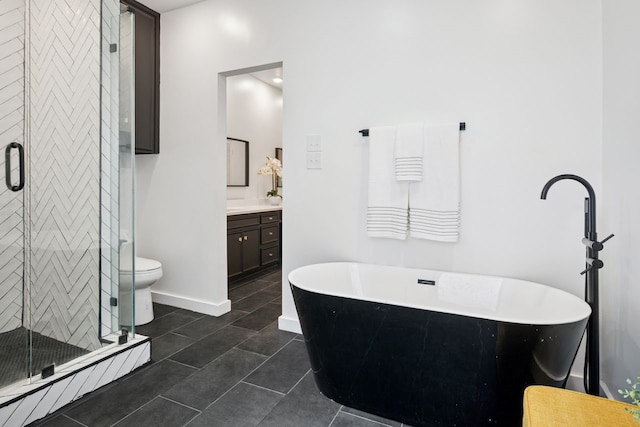 10823 Stone Canyon Rd, Dallas, TX 75230 - full bathroom with vanity, a freestanding tub, a stall shower, tile patterned flooring, and toilet