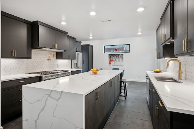 10823 Stone Canyon Rd, Dallas, TX 75230 - kitchen with a sink, a kitchen island, stove, tasteful backsplash, and light stone counters
