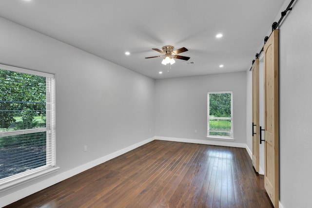 815 N Seven Points Dr, Kemp, TX 75143 - empty room featuring a barn door, dark wood-style flooring, baseboards, a ceiling fan, and recessed lighting