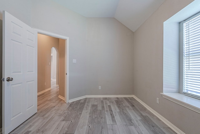 6937 Andress Dr, Fort Worth, TX 76132 - unfurnished room with lofted ceiling, arched walkways, light wood-style flooring, and baseboards
