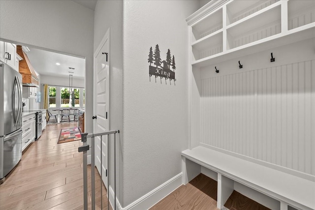 184 Lakeview Cir, Pilot Point, TX 76258 - mudroom with light wood finished floors, a textured wall, and baseboards