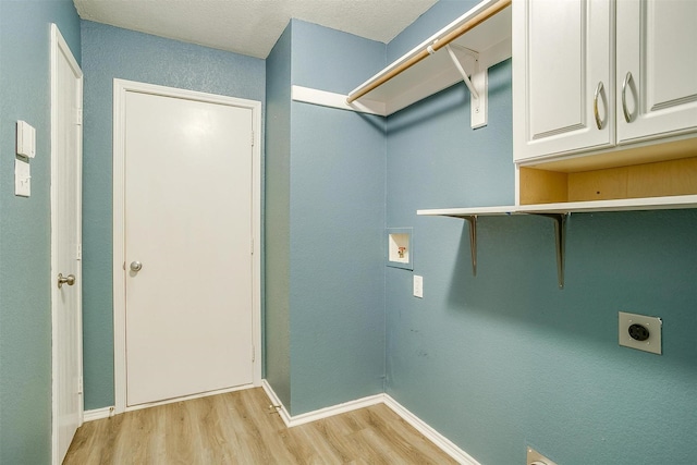 9805 Rockledge Rd, Fort Worth, TX 76108 - laundry room featuring hookup for an electric dryer, light wood-style floors, cabinet space, and baseboards